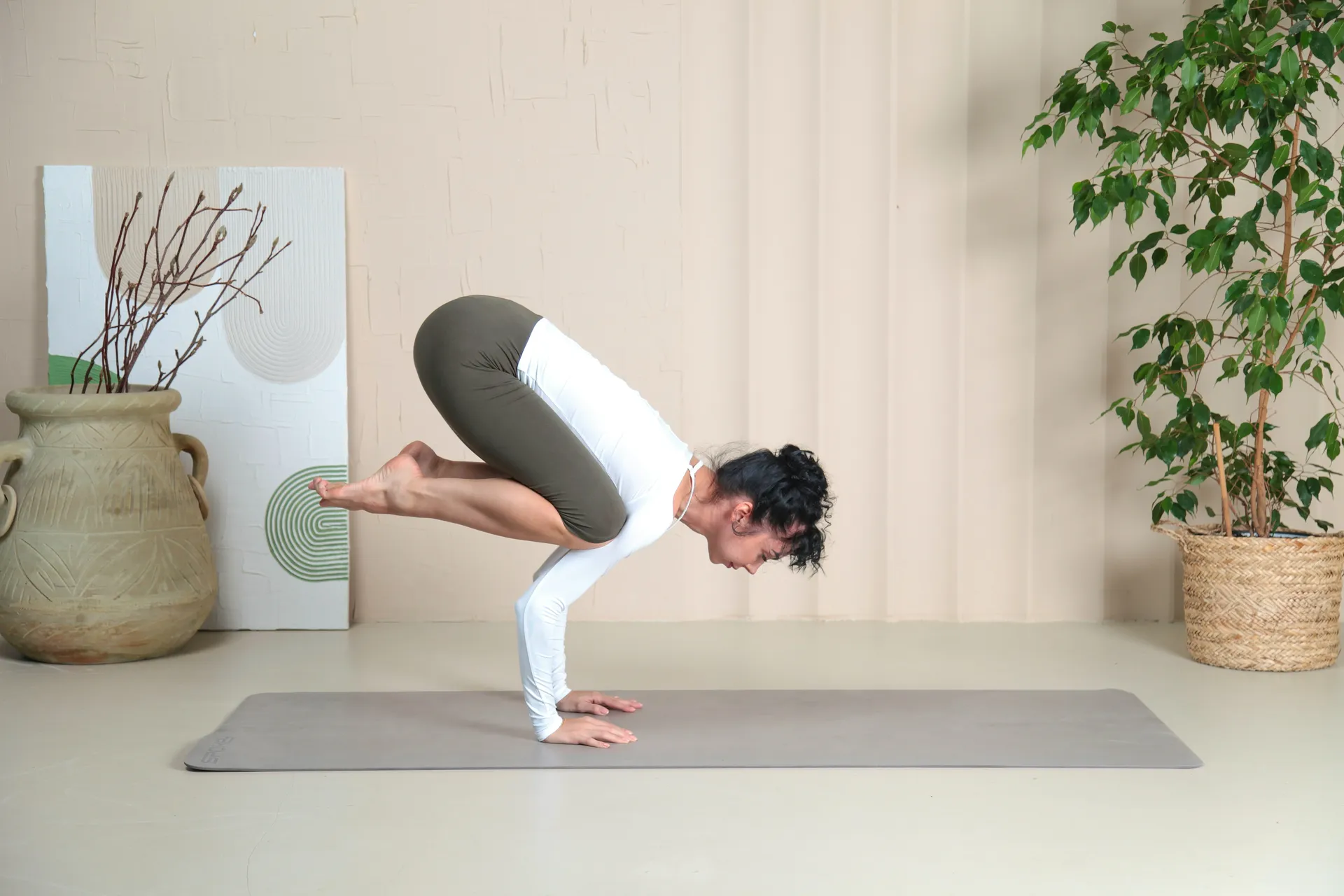 Una mujer está haciendo una postura de yoga en una colchoneta